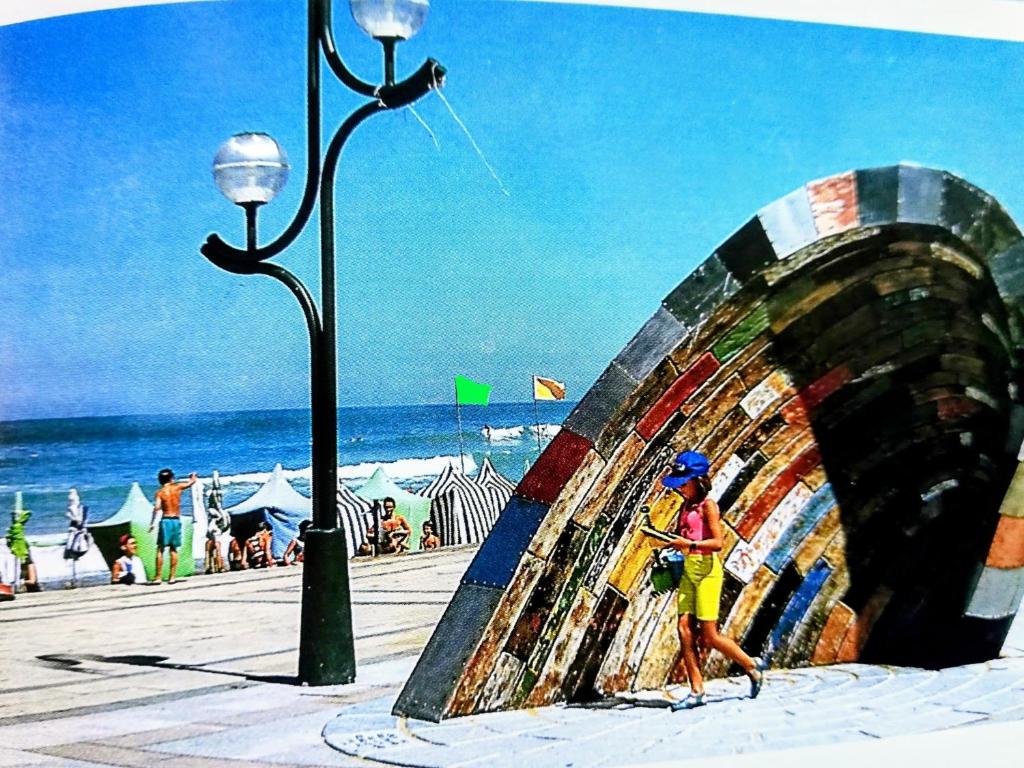 a painting of a woman walking on the beach at alaia apartamento in Zarautz