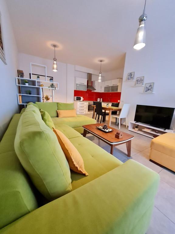 a living room with a green couch and a table at Gjiri I Lalzit apartament in Draç