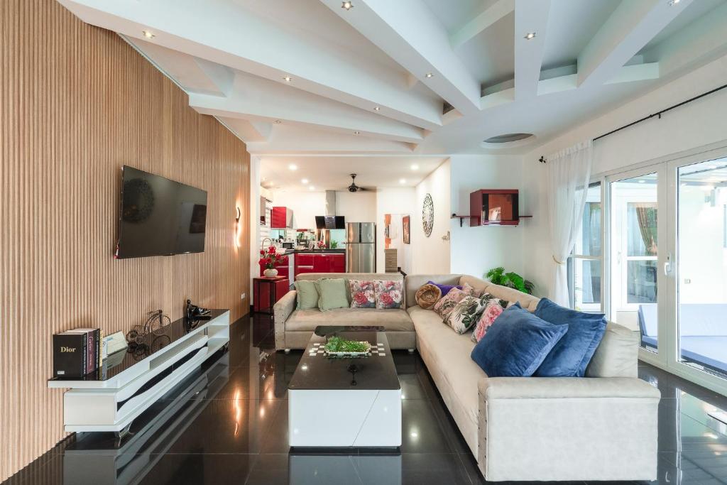un soggiorno con un divano e una TV di Platinum Villa Rawai 76 a Rawai Beach