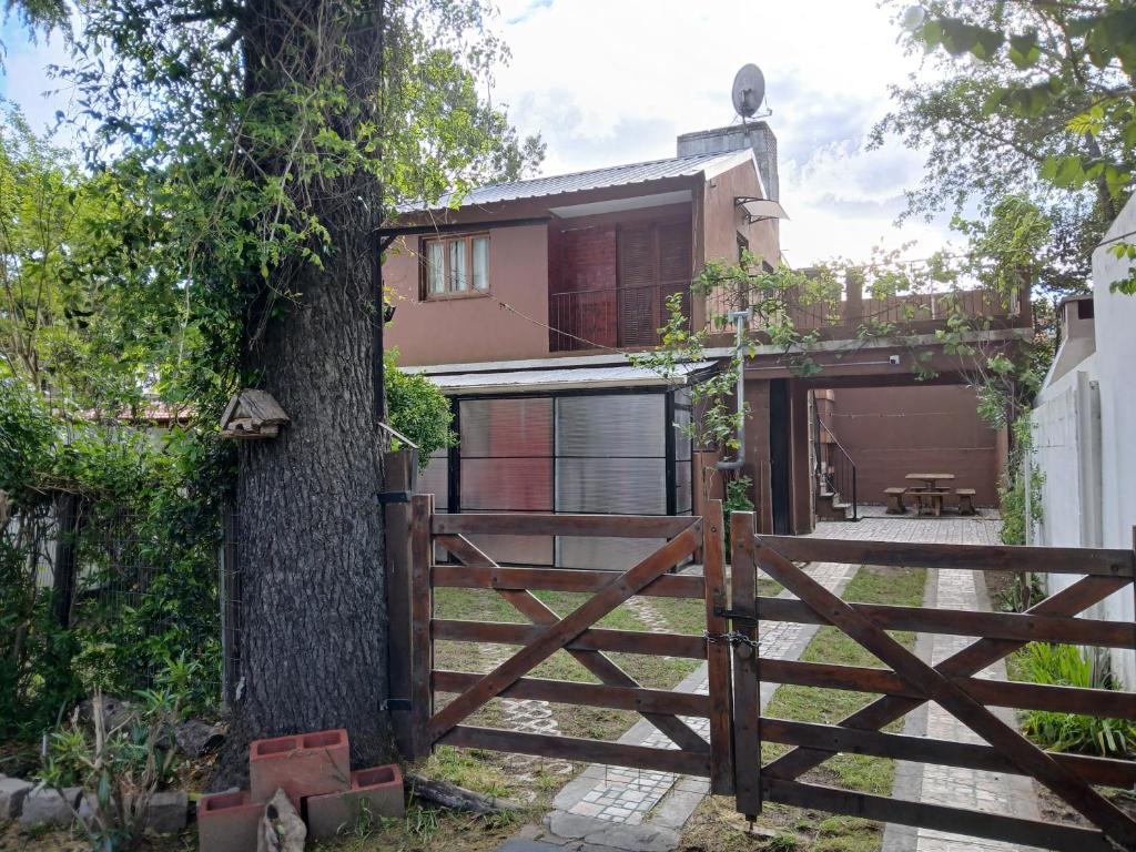 a wooden fence in front of a house with a tree at Lo de Alfonso in San Bernardo
