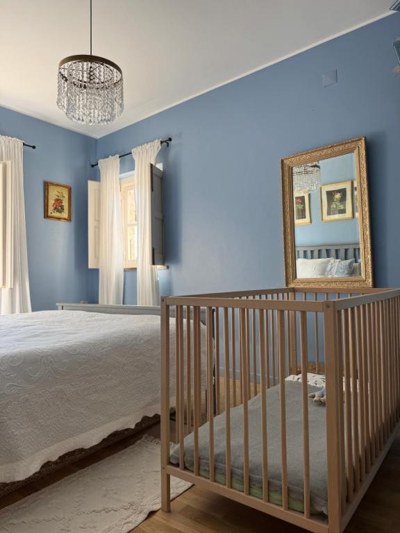 カスカイスにあるJardim de Cascaisの青い壁とベビーベッドと鏡のある寝室
