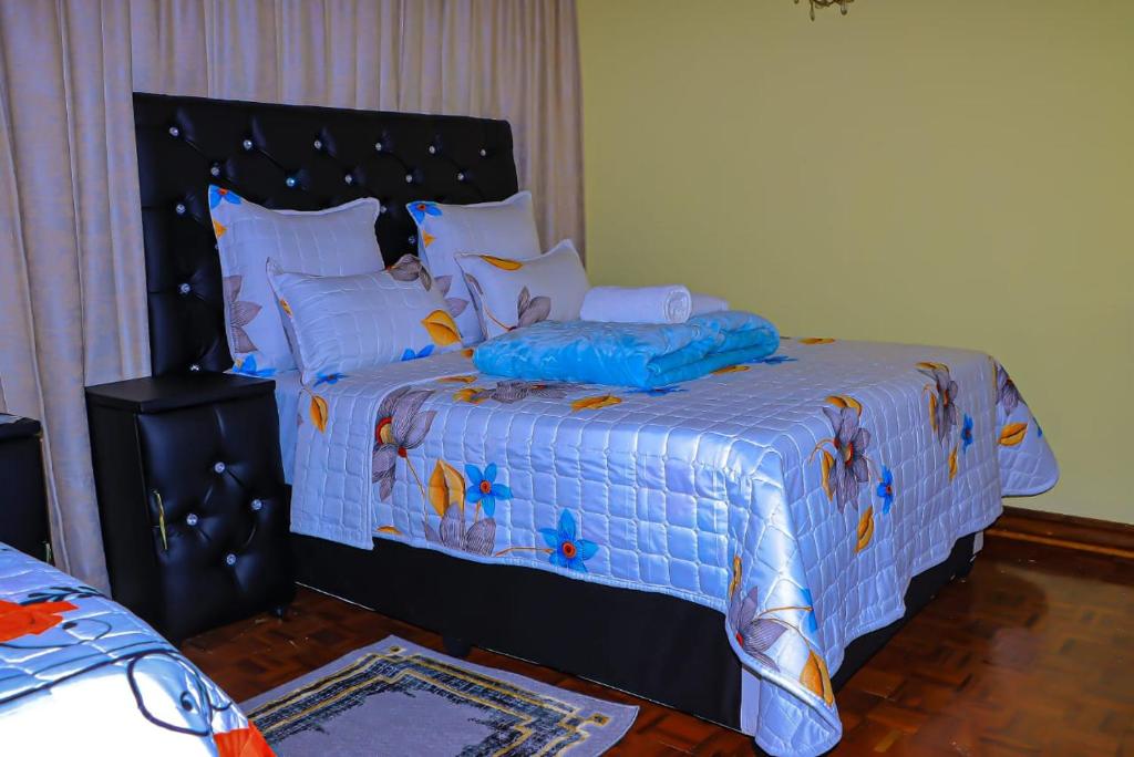 a bedroom with a large bed with a blue comforter at E Point guest house in Johannesburg