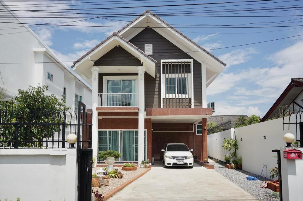 a house with a car parked in the driveway at Browny house - Doi Suthep View in Chiang Mai