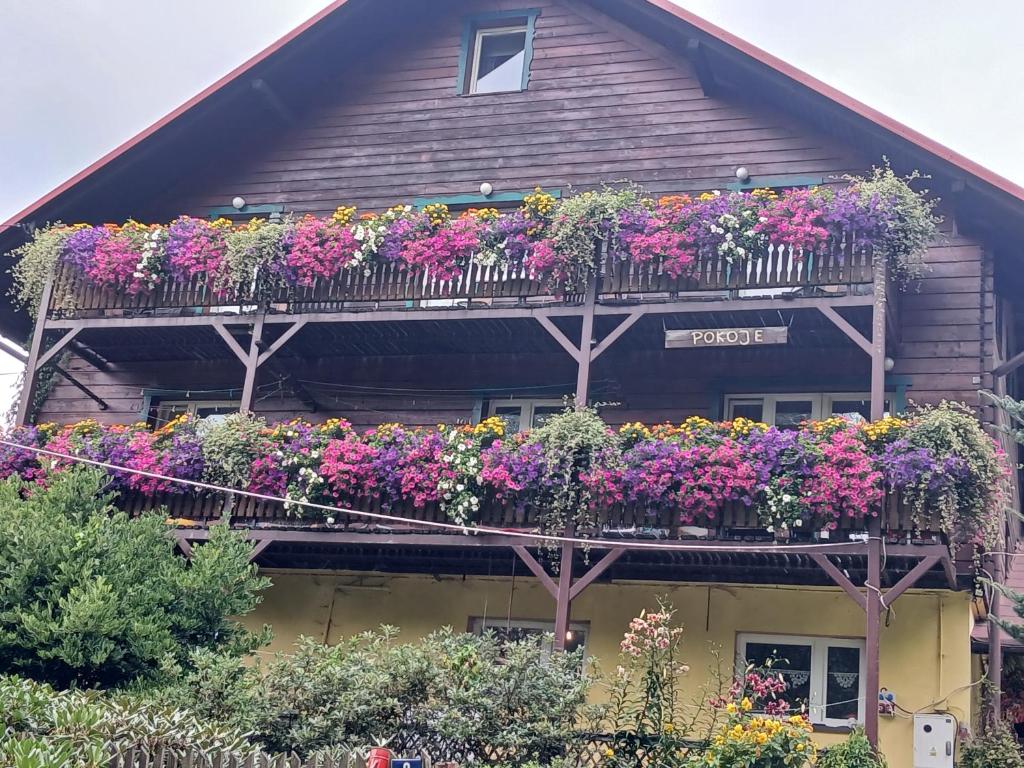 a house with lots of flowers on its balcony at U TKOCZA Agroturystyka in Wisła
