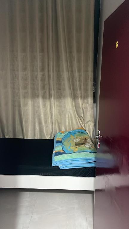 un lit avec un rideau et une couverture dessus dans l'établissement Boutique Bed Space - MBZ, à Muşaffaḩ