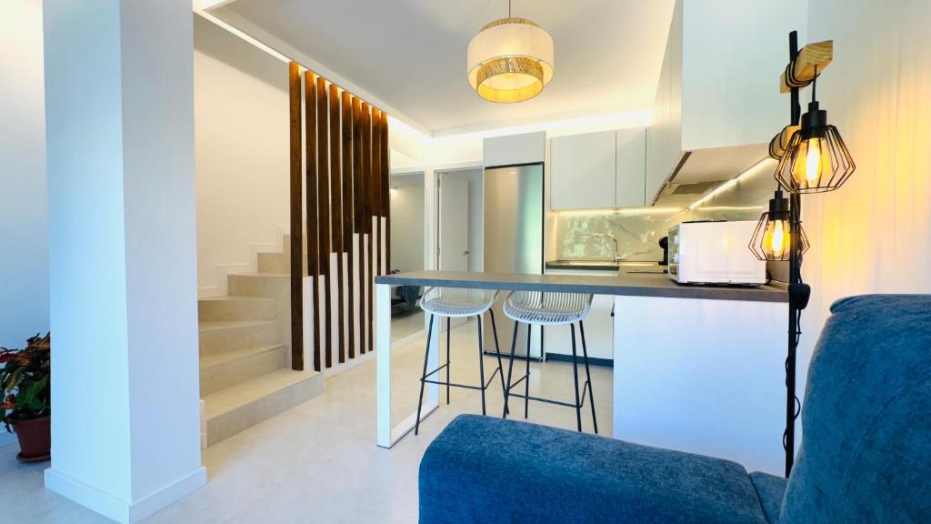 a kitchen with a bar with stools in a room at Bungalow Diana in Maspalomas