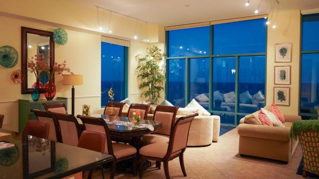 een woonkamer met een tafel, stoelen en een bank bij Penthouse Jr Unrivaled Luxury Insane Views in South Padre Island