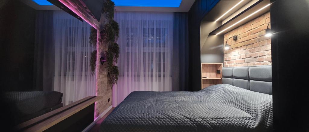 a small bedroom with a bed and a window at Apartament centrum - loft Plac Piłsudskiego in Gliwice