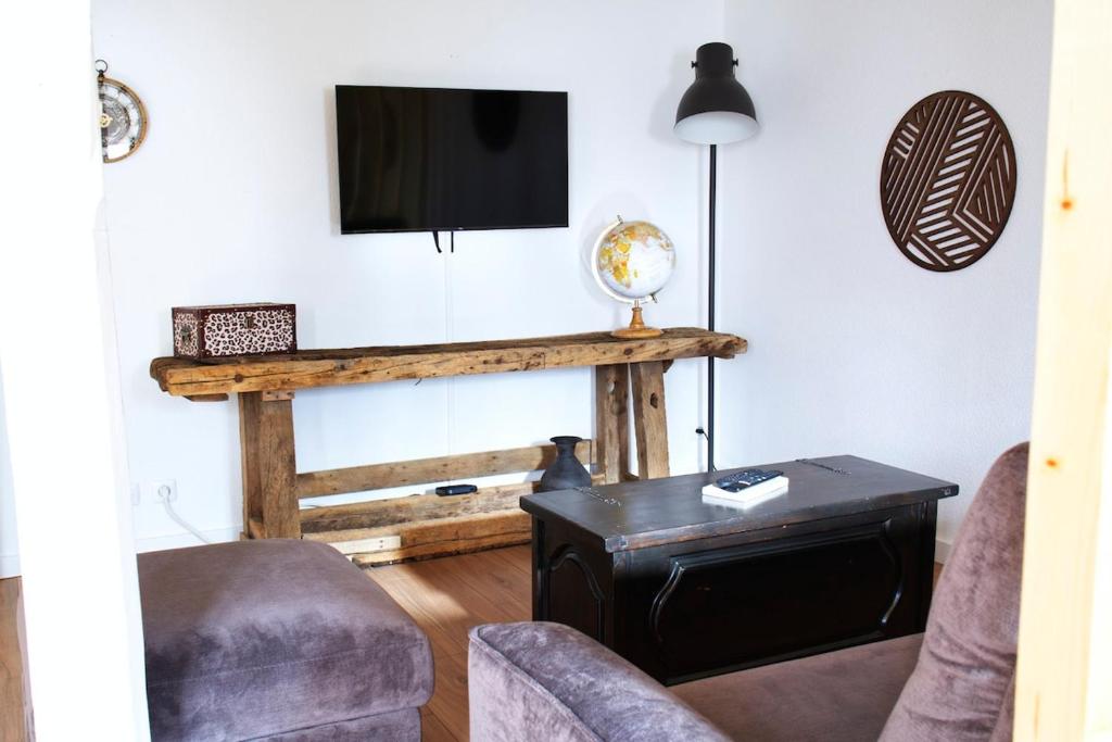 Una sala de estar con un televisor, un sofá y una mesa. en L'atypique des choux, en Les Choux