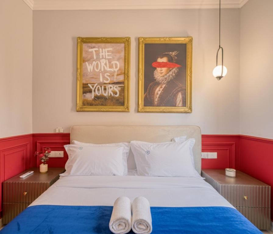 a bedroom with a bed with two pictures on the wall at Travelholic Residence Near Mivida in Cairo