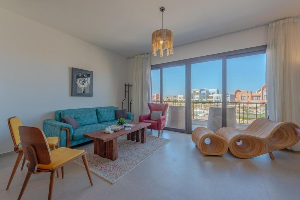 a living room with a couch and a table and chairs at Lumina -1 BR Chalet in Kamaran, Gouna in Hurghada