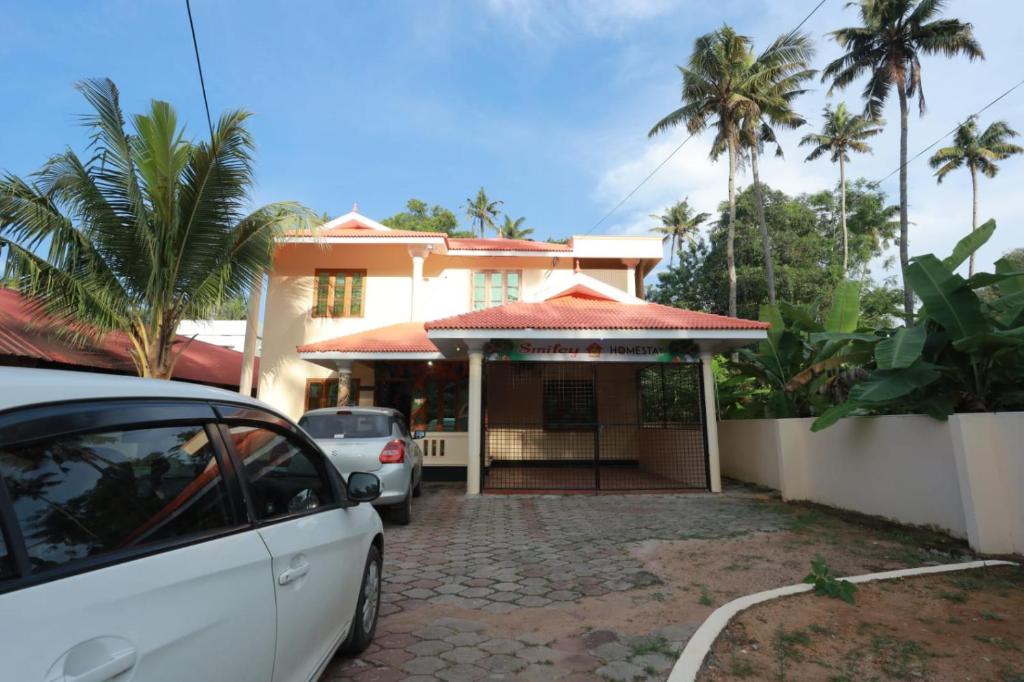 a white car parked in front of a house at Smiley Homestay in Varkala
