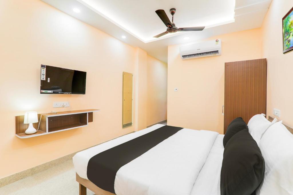 a bedroom with a bed and a flat screen tv at Hotel O Happy Times Vishveshwar Park in Gomti Nagar
