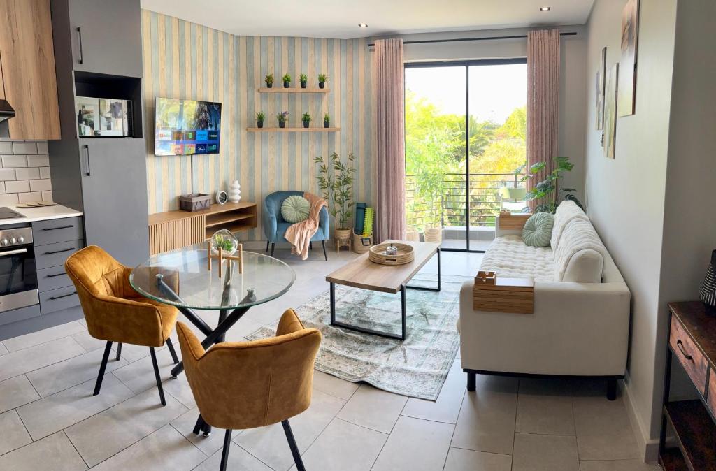 a living room with a glass table and chairs at Table View Escape in Cape Town