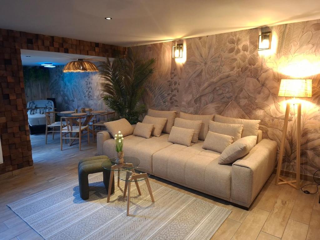 ein Wohnzimmer mit Sofa und Tisch in der Unterkunft Thermo'Spa - Gîte Spa Privatif in Calais