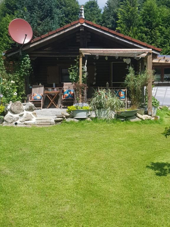 a house with chairs and a table in a yard at Ferienhaus Haigrub in Perasdorf