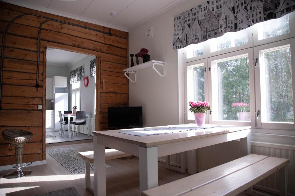 un soggiorno con tavolo bianco e alcune finestre di Willa Wanha Apteekki a Seinäjoki