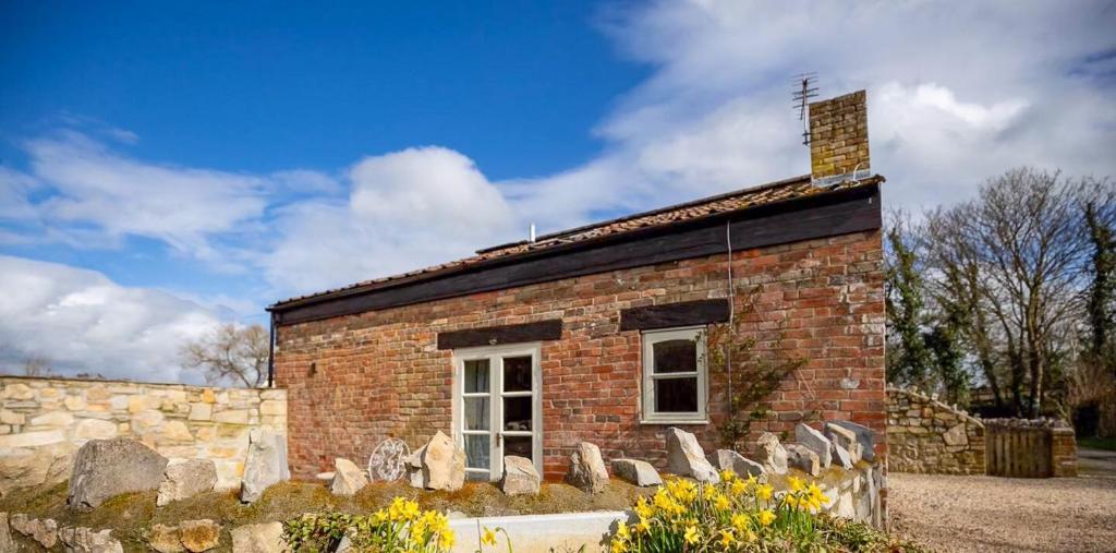 a brick building with a cross on top of it at Wilf's Barn, romantic cottage with free parking in Wedmore