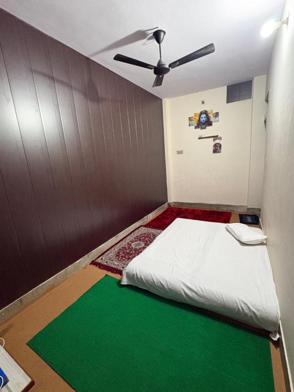 バラナシにあるPankali niwasのベッドと天井扇風機のある部屋