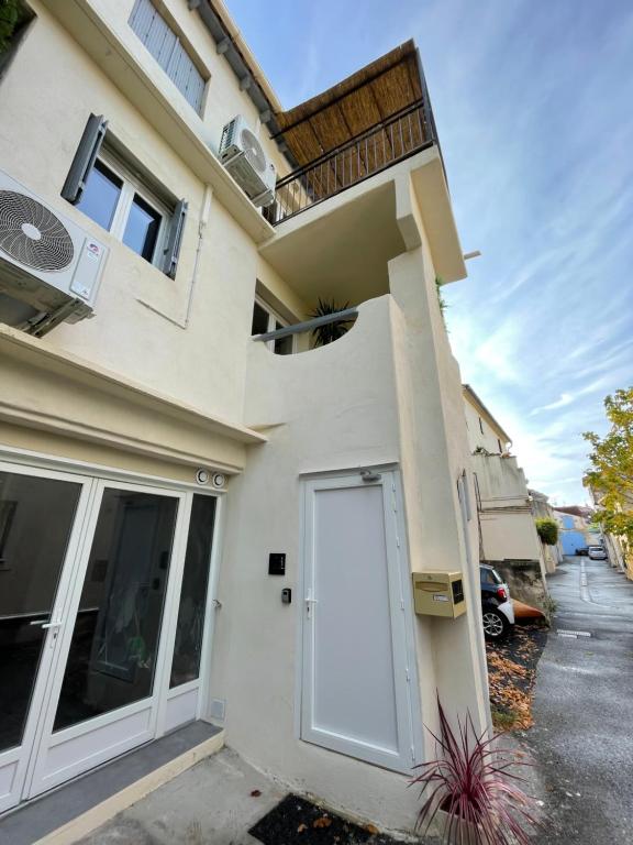 une maison avec une porte blanche sur son côté dans l'établissement Appartement de village avec balcon rooftop, à Maillane