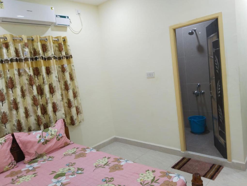 a bedroom with a bed and a shower and a mirror at Guru Mahal in Pondūr