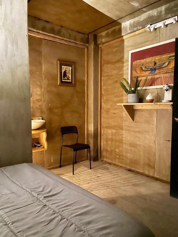 a bedroom with a chair and a wall with a painting at EB5 Escape Tzununa, Lake Atitlan Room #3 - two minute walk to the Lake in Tzununá