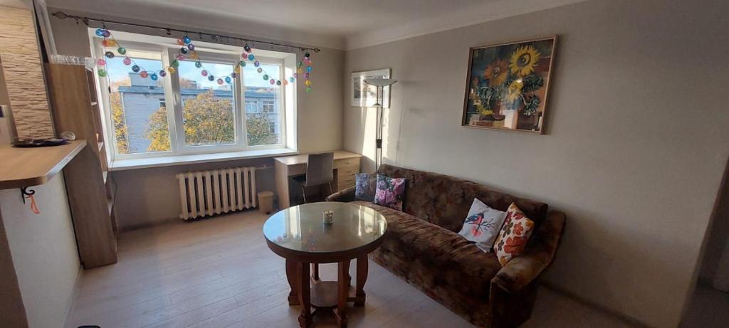 a living room with a couch and a table at Wolfs apartment in Rīga