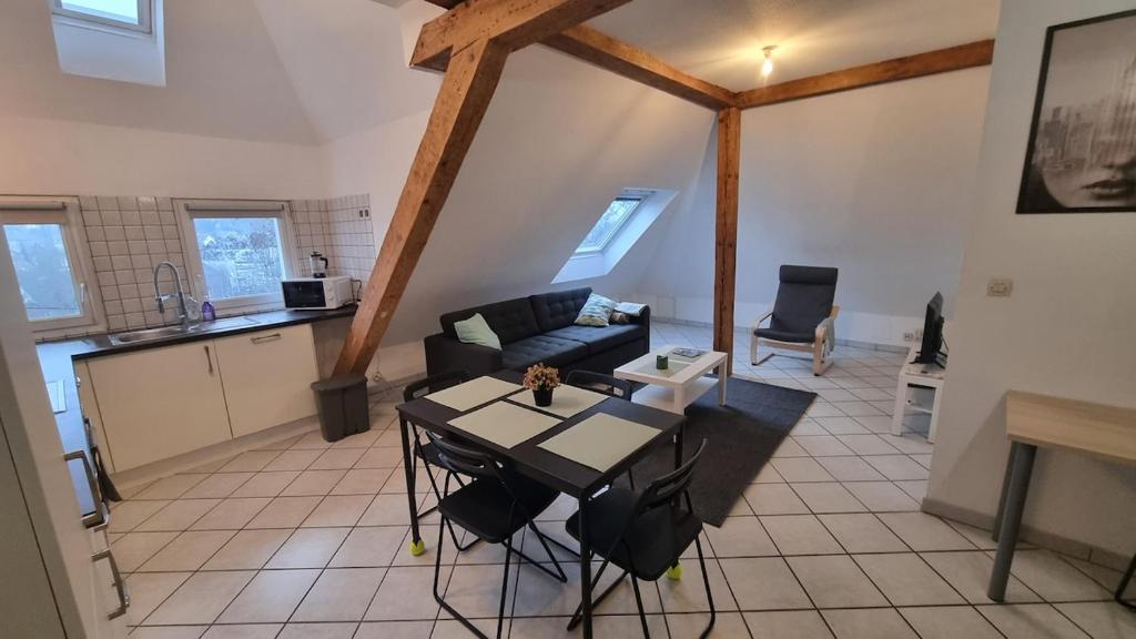 una sala de estar con un sofá y una mesa en Duplex sous mon toit, en Altkirch