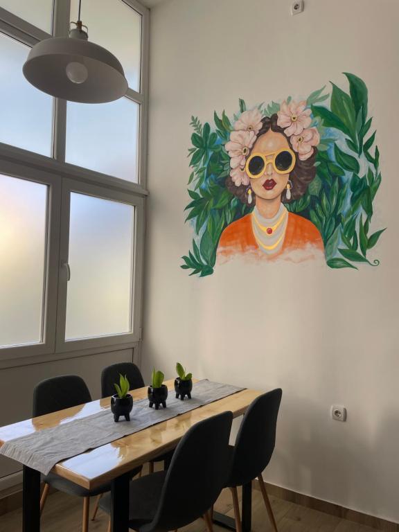 una mesa de comedor con una pintura de una mujer en La Hitana, en Lazarevac