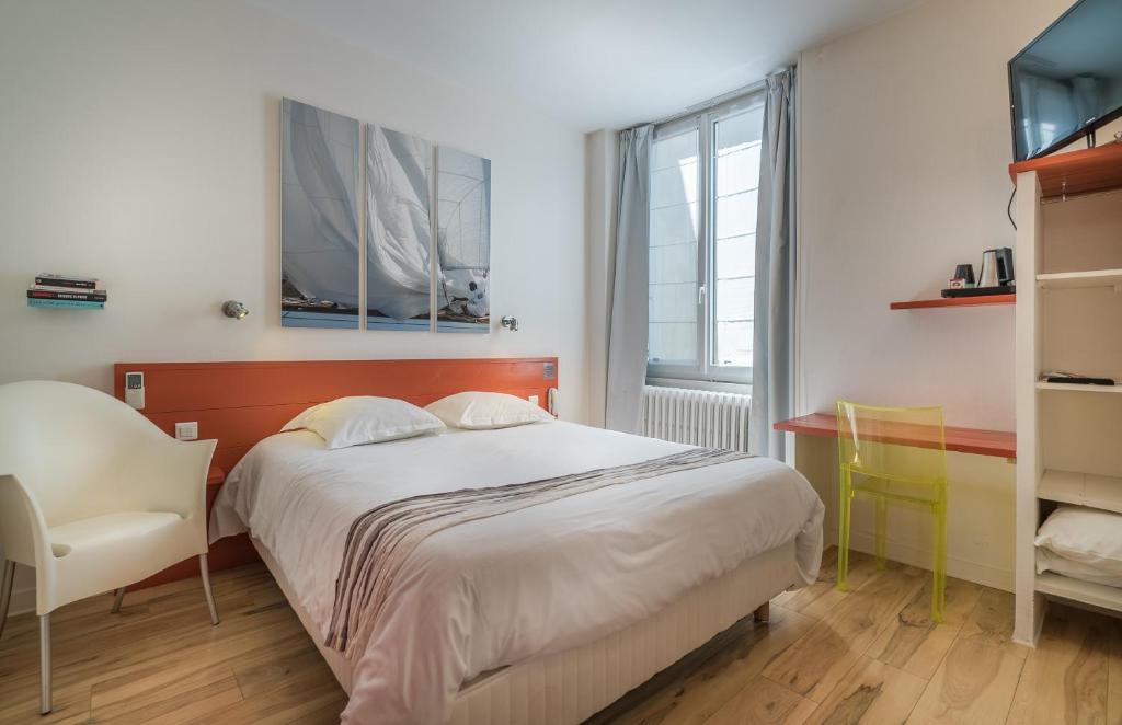 - une chambre avec un lit, une chaise et une fenêtre dans l&#39;établissement Hotel La Marine, Vieux Port, à La Rochelle