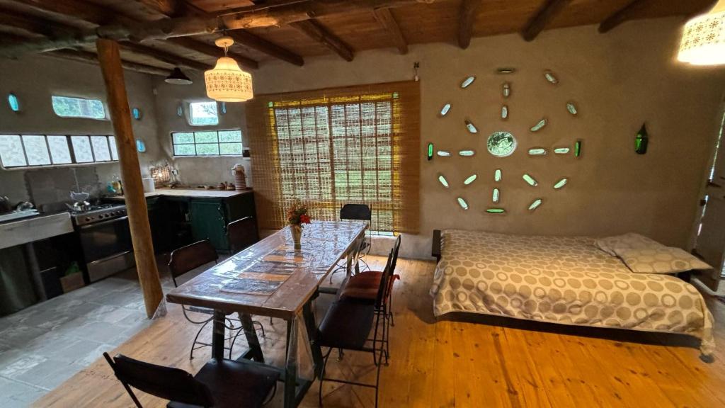 une chambre avec un lit et une table avec des chaises dans l'établissement Tierra de Arroyo, Mallin-Tanti, à Tanti