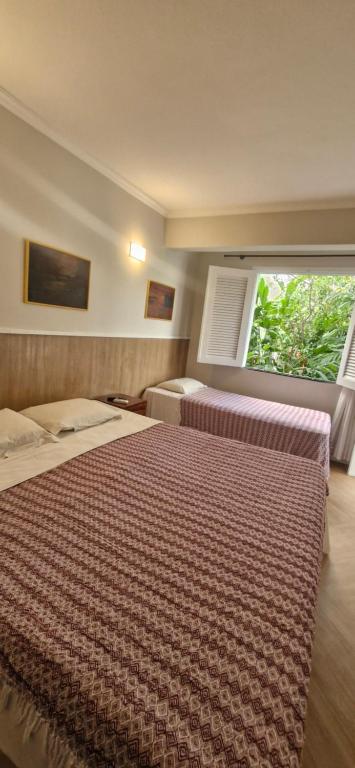 a hotel room with a bed and a window at Ecopousada Miriti in Belém