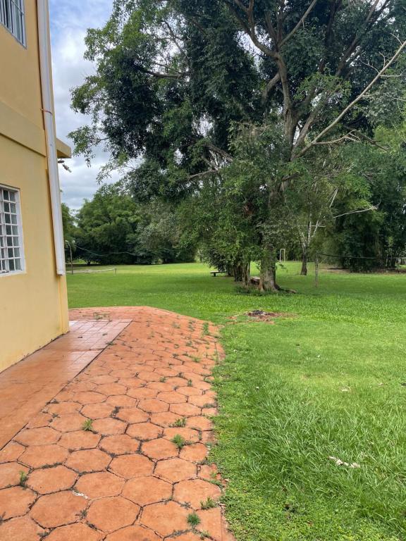 een stenen loopbrug naast een huis met een boom bij Suíte rural in Foz do Iguaçu