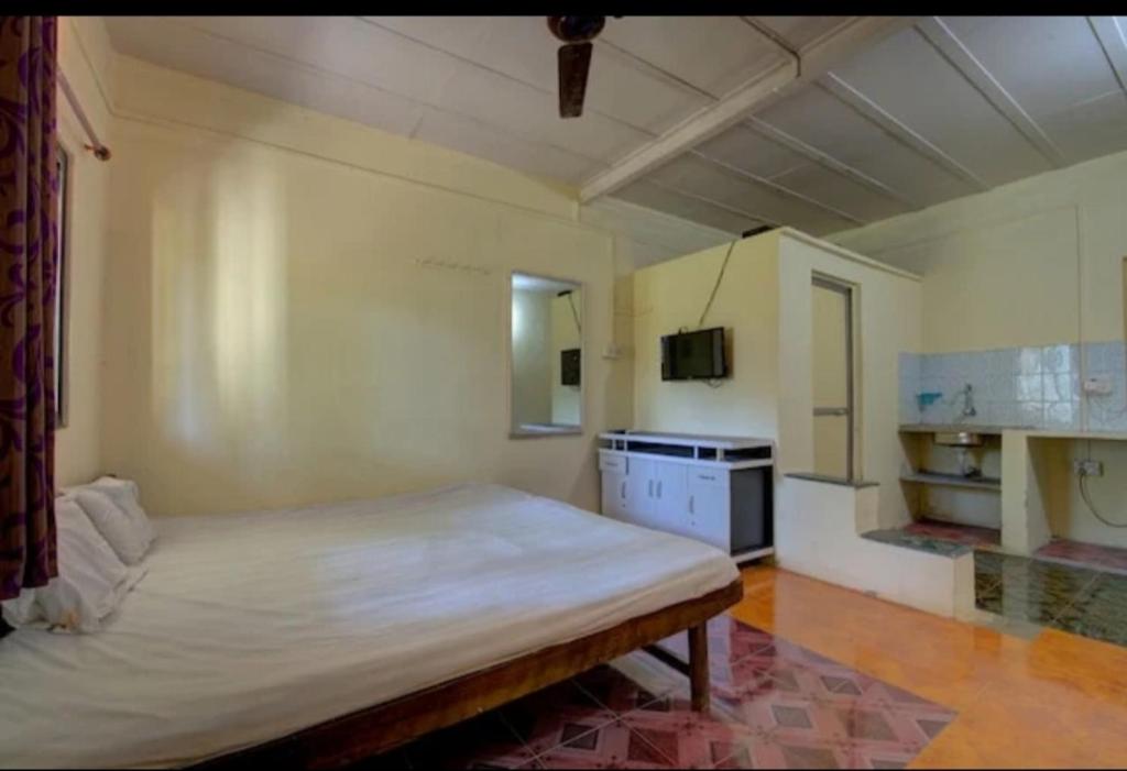 a bedroom with a large bed and a kitchen at Yellow House in Zirad