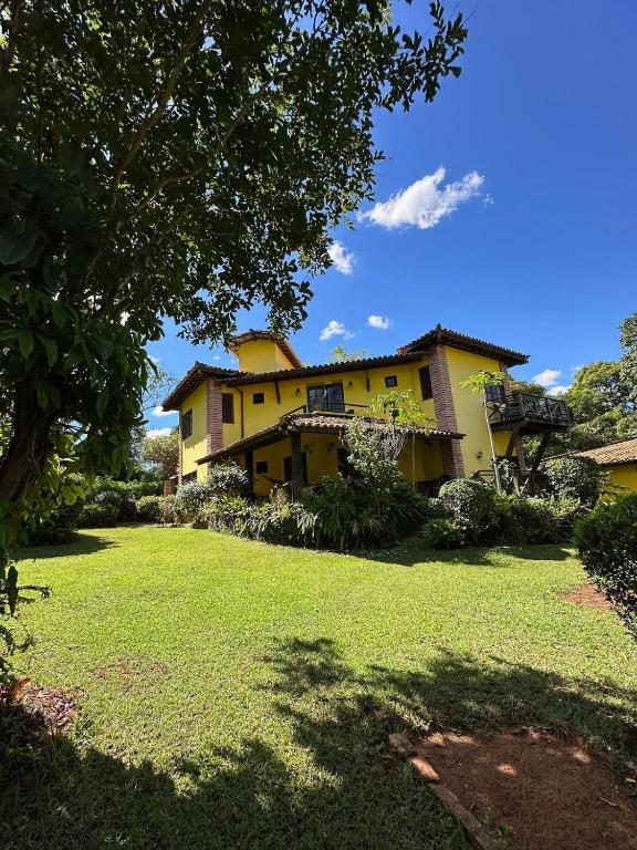 a large yellow house with a large yard at Casa Paraíso do Ribeirão in Lençóis