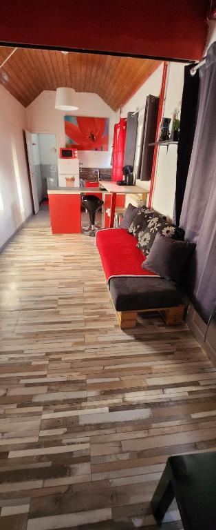 Una sala de estar con un sofá sobre un suelo de madera. en Les coquelicots, en Maimbeville