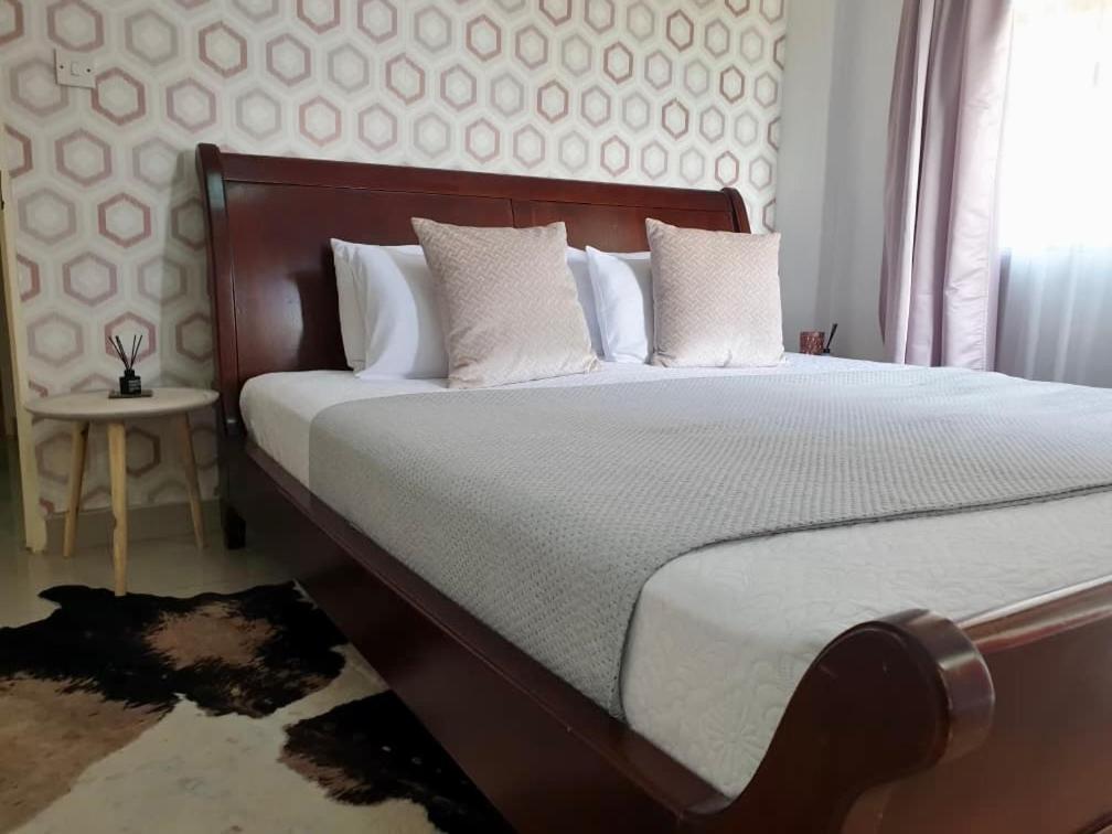 a bedroom with a large bed with white pillows at Sages Place in Gaborone
