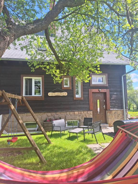 a yard with a hammock in front of a house at Agroturystyka Cieślarówka in Lubawka