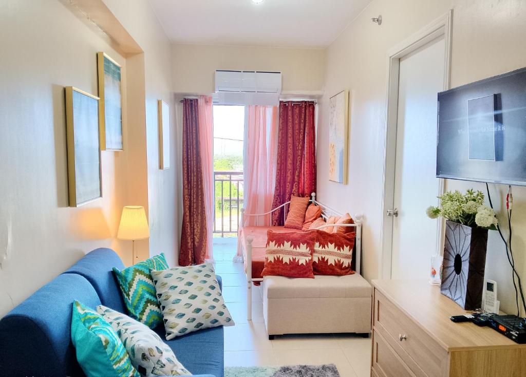 a living room with a blue couch and a chair at Louisse 223 Avida in Molo