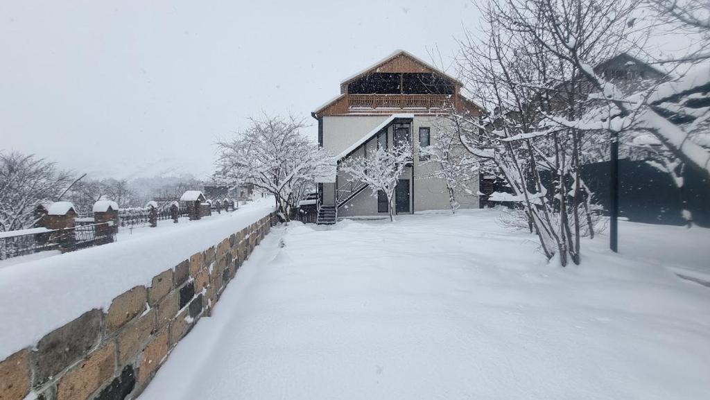 un edificio cubierto de nieve junto a una pared en Nazani apartments, private apartments ,апартаменты целиком, en Dilijan