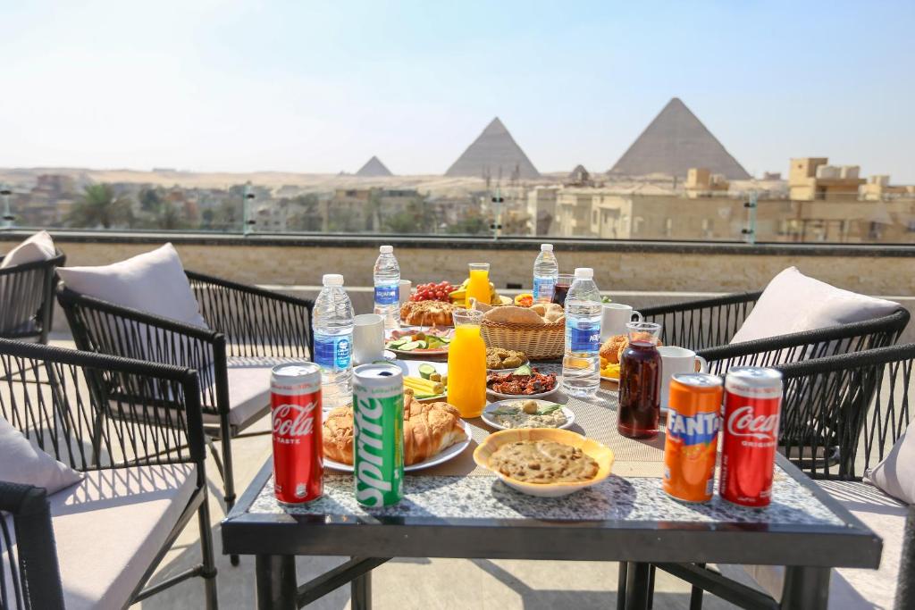 开罗The SACRED ANGLE pyramids view的金字塔顶上摆放着食物和饮料的桌子