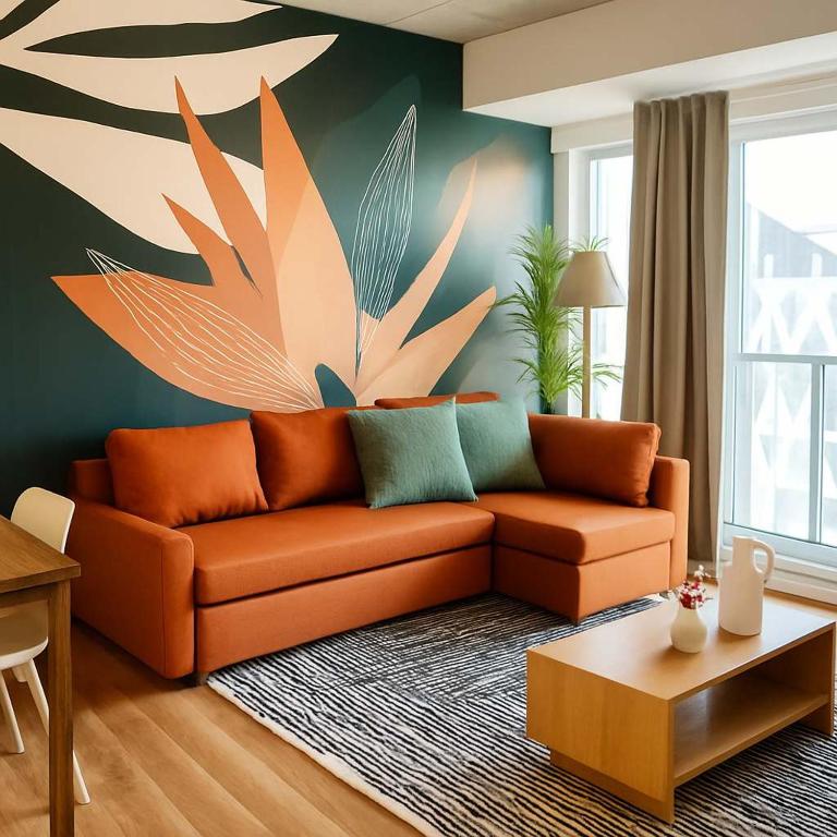 an orange couch in a living room with a painting at The 708 - For 4 - Free Parking - BBQ in Quebec City