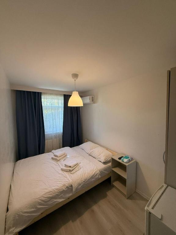 Un dormitorio con una cama con una lámpara y una ventana. en Şişli Suites - Room44, en Estambul