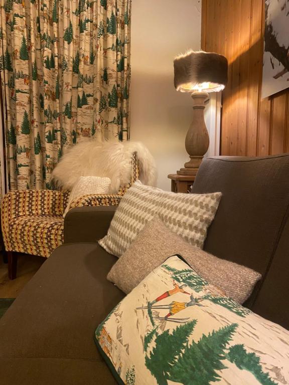 a living room with a couch and a lamp at Grande Marmotte, Ski aux pieds, Le Refuge du Montagnard, Arc 1950 in Bourg-Saint-Maurice