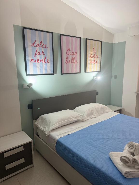 a bedroom with four pictures on the wall at Alura Apartments in Nola