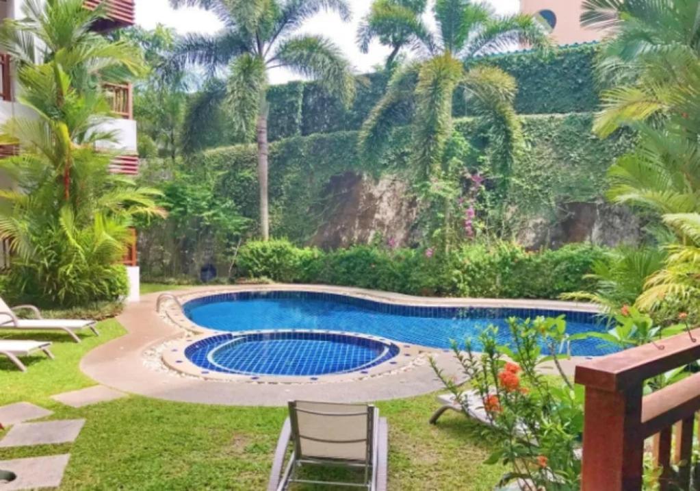 a swimming pool in a yard with palm trees at 41 квадратный метр, апартамент на пляже Сурин in Surin Beach