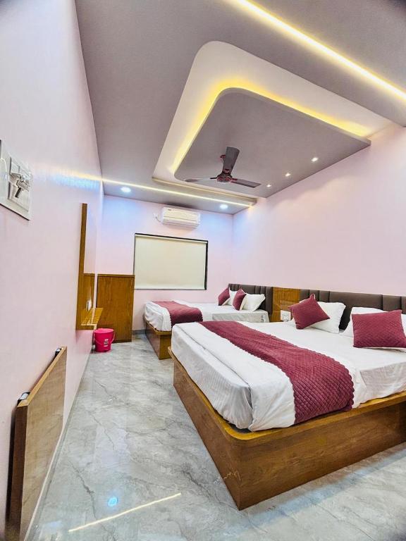 a hotel room with two beds in a room at Sairam Residency in Ellora