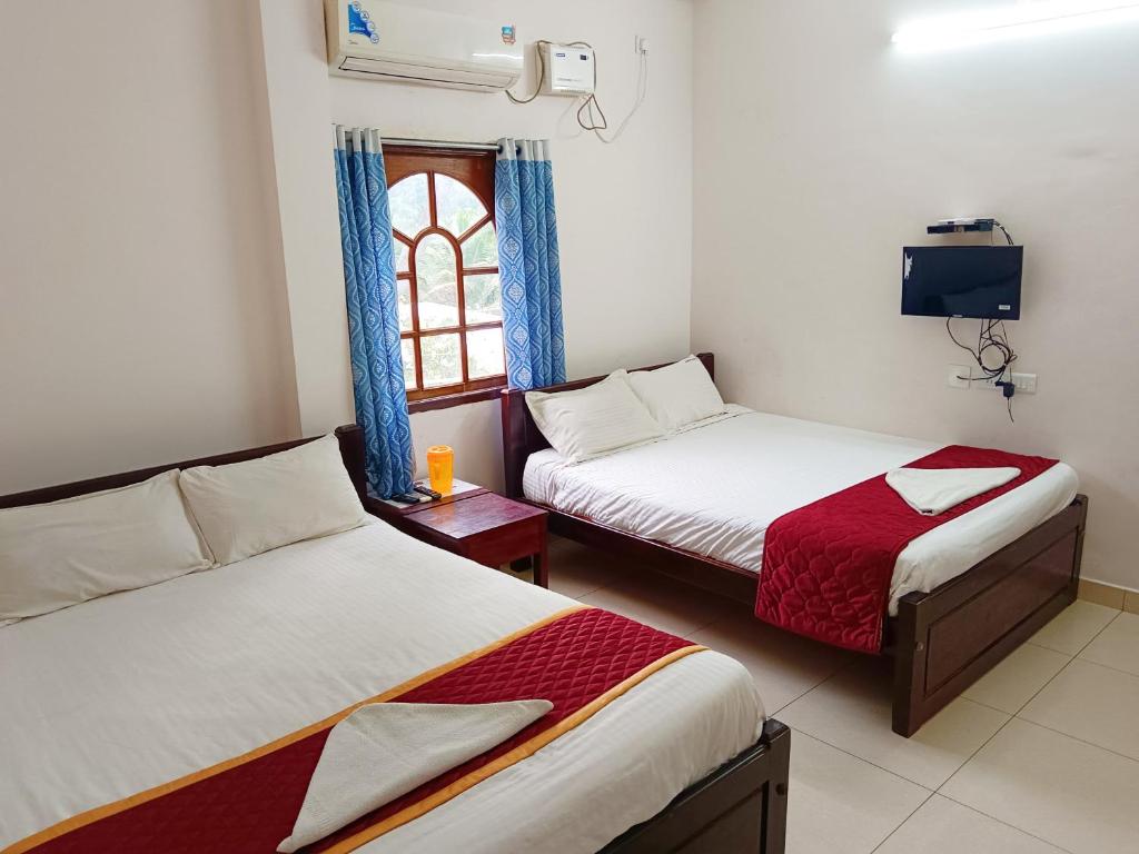 a room with two beds and a window at De Dreams beach in Puducherry