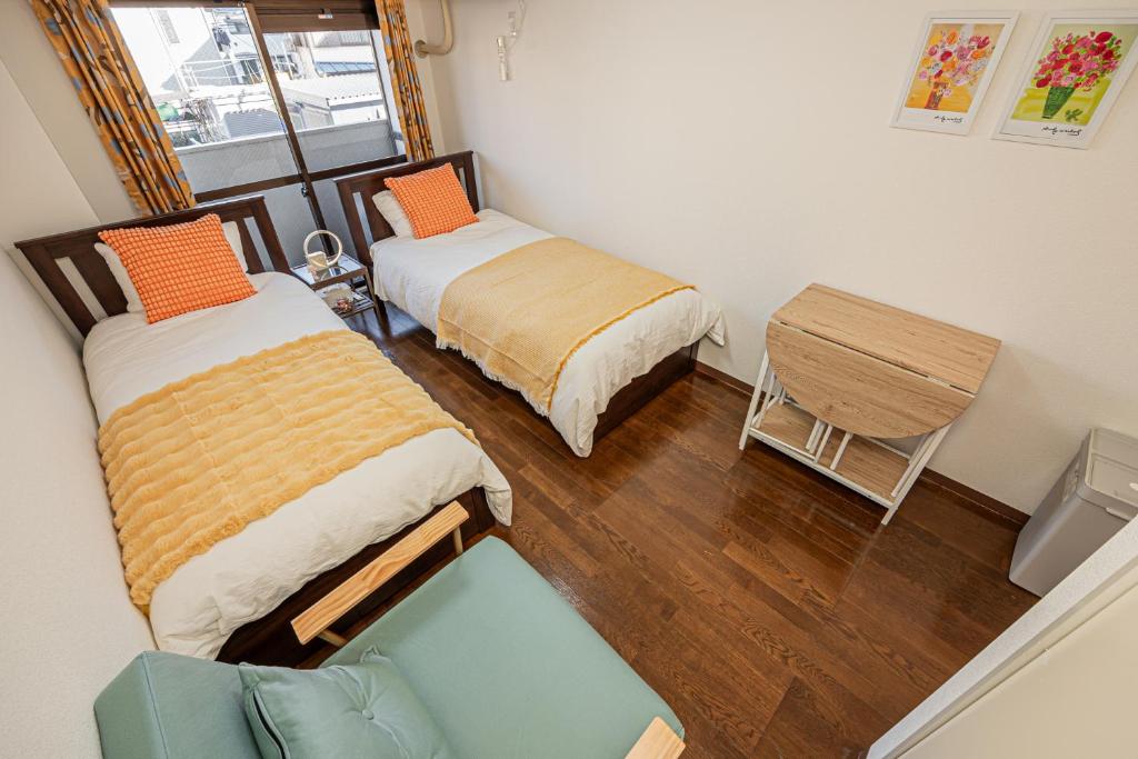 東京にあるsakura 202のベッド2台とソファのある小さな部屋