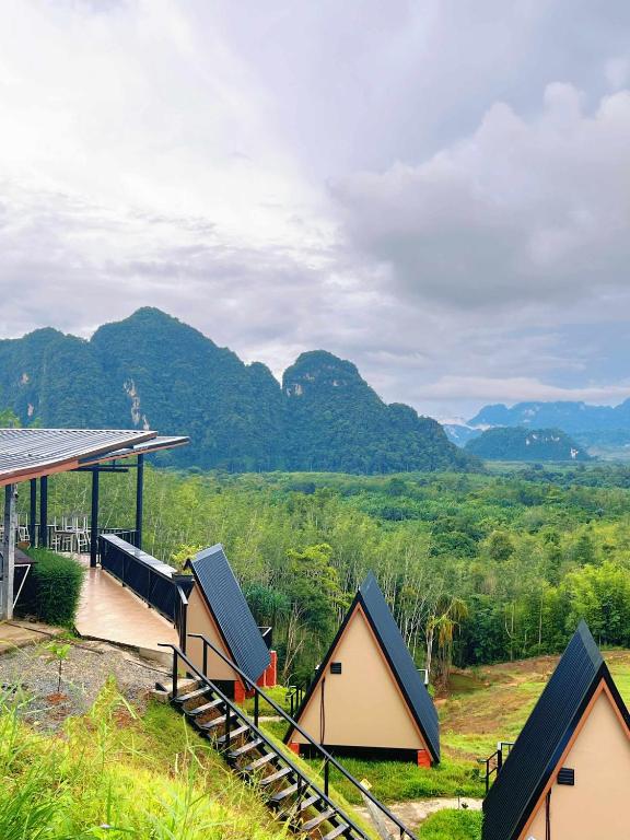 a group of small houses with mountains in the background at Khaosok Campsite in Khao Sok National Park